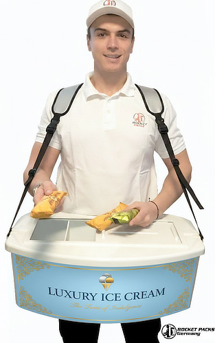 Ein mobiler Eiscreme-Bauchladen mit spezialisierter Thermoisolierung für den Verkauf von Speiseeis und tiefgekühlten Snacks. Das Bild zeigt das kompakte Design mit weißer Oberfläche und den ergonomischen Schultergurten, ideal für den Einsatz an Stränden, in Freizeitparks oder bei sommerlichen Firmenevents.